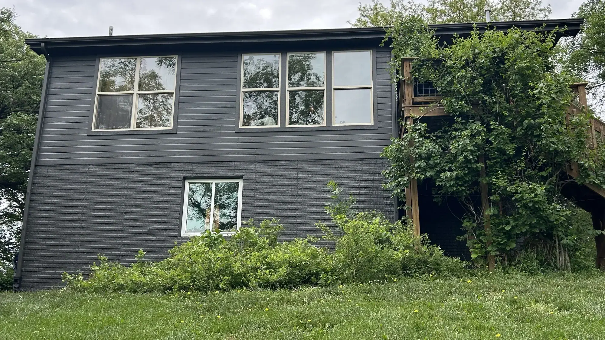 Dark Gray Horizontal Siding Home Dark gray horizontal siding residential home with white-trimmed windows and wood deck in Omaha.