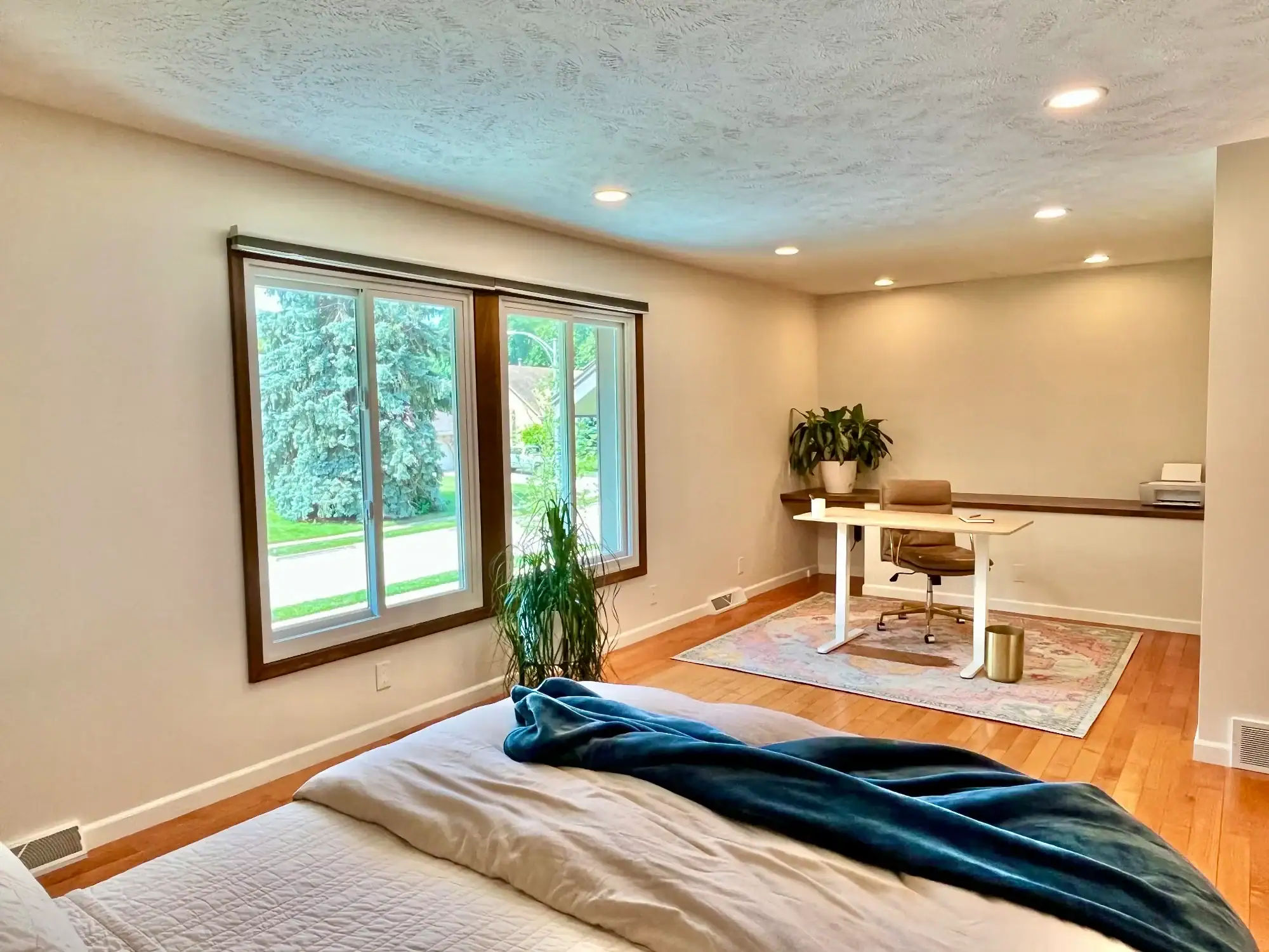 Master Bedroom Office Painted Cream painted master bedroom and office with textured ceiling, hardwood flooring, sliding glass doors, and built-in desk in